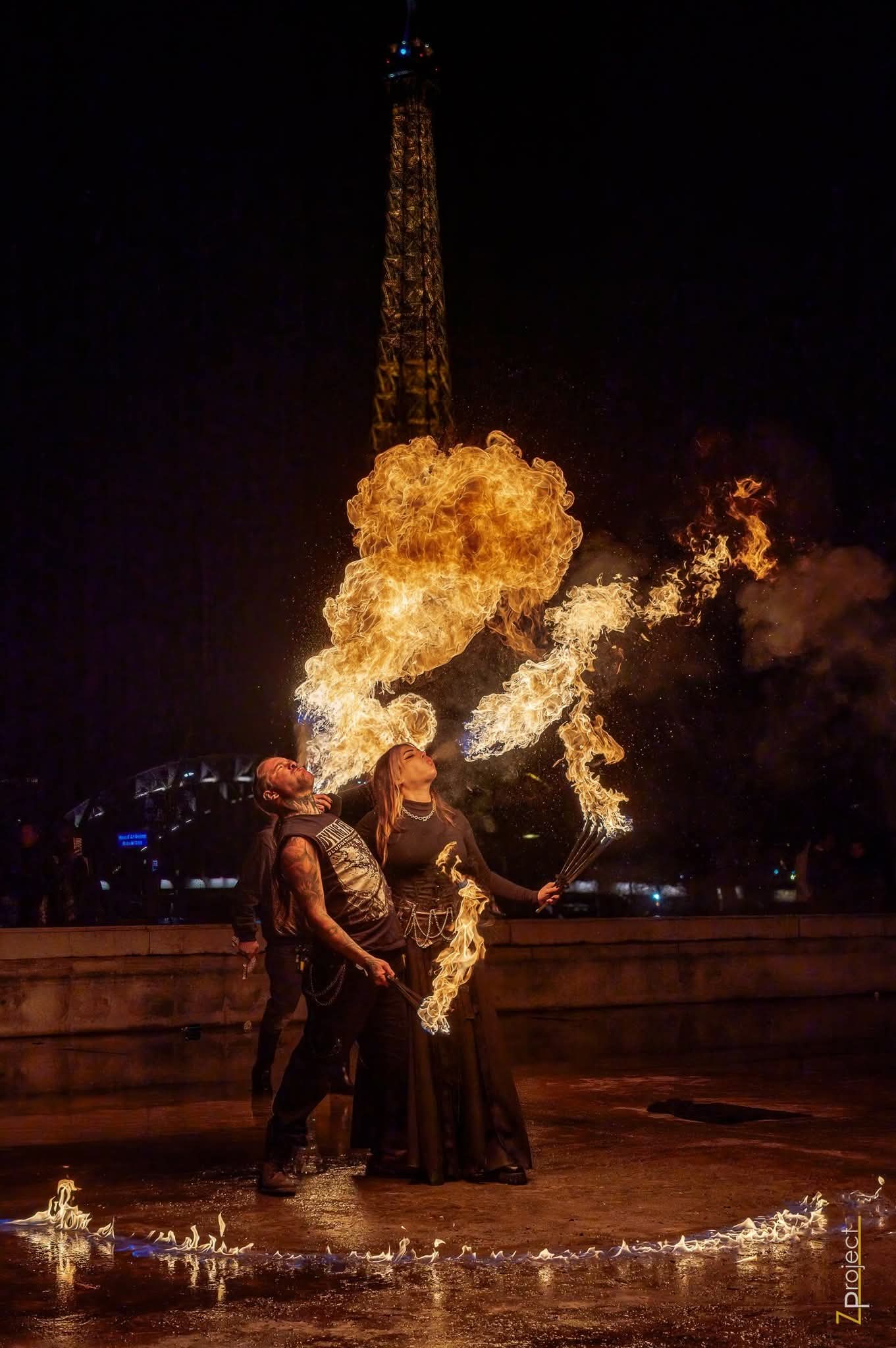 Silhouette de performer devant d'immenses flammes